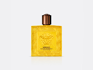 Produktbild des Parfums 'Versace Eros Flame Energy'. Der quadratische Flakon ist in leuchtendem Gelb gehalten und trägt ein markantes, erhabenes Muster mit dem Medusa-Kopf in der Mitte. Der Verschluss ist bronzefarben. Der Hintergrund ist hellgrau und neutral.