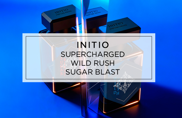 Ein futuristisch beleuchtetes Arrangement mehrerer Initio Parfumflakons in dunklem Design vor blauem Hintergrund, überlagert von einem transparenten Textfeld mit den Worten „Supercharged Wild Rush Sugar Blast