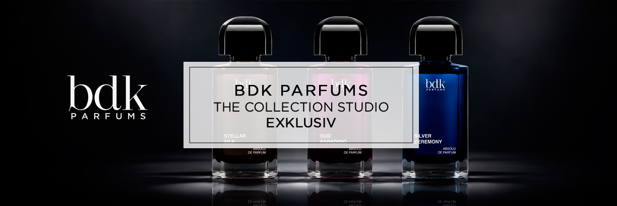 Drei elegante Parfumflakons von BDK Parfums stehen nebeneinander vor dunklem Hintergrund, stilvoll ausgeleuchtet mit Spiegelungen und dem Logo links daneben.