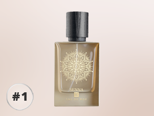 Parfumflakon von Eau de Moe Senna mit goldfarbenem Glas, schwarzem Verschluss und ornamentalem Muster auf der Vorderseite