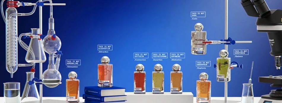 Hormone Paris Parfumkollektion inszeniert im Laborstil mit Glasapparaturen, Mikroskop und mehreren Duftflakons auf blauem Hintergrund