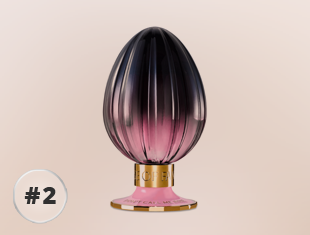 Parfumflakon Danger Eau von House of Fanatics in eiförmiger Form mit geriffeltem Glas, Farbverlauf von Schwarz zu Rosé und goldfarbenem Sockel vor hellem Hintergrund