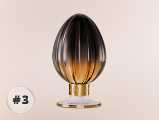 Parfumflakon Amber Ghost von House of Fanatics mit geriffeltem Glasdesign, Farbverlauf von Schwarz zu Amber und goldfarbenem Sockel vor hellem Hintergrund