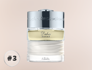 Parfumflakon The Spirit of Dubai Bahar mit silbernem Verschluss, transparentem Glas und weiß strukturierter Basis, gefüllt mit hellgelbem Duft, freigestellt vor hellem Hintergrund.