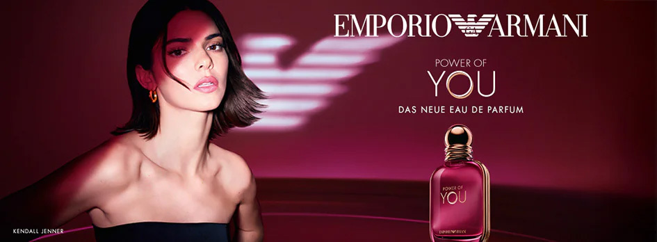 Kampagnenmotiv von Emporio Armani „Power of You“ mit Kendall Jenner vor bordeauxfarbenem Hintergrund und roséfarbenem Parfumflakon.