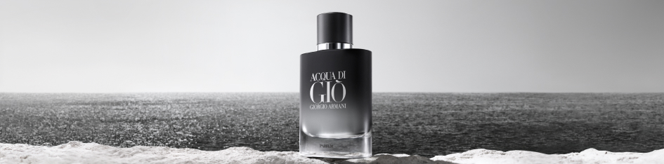 Produktbild des Parfums 'Acqua di Giò Parfum' von Giorgio Armani. Eine schwarze Flasche mit silberner Aufschrift und glänzender Kappe steht mittig auf einem Felsen am Meer. Der Hintergrund zeigt ein ruhiges, endloses Meer in schwarz-weiß, das in einem nebligen Horizont verschwindet.