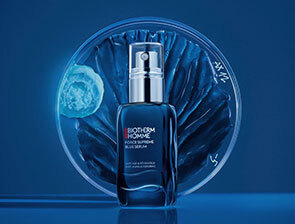Ein Anti-Aging-Serum von Biotherm Homme steht vor einem blauen, mondähnlichen Hintergrund mit einem strahlenden Effekt.