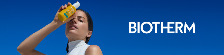Werbung für Biotherm Sonnenschutz. Eine Frau in weißem ärmellosen Oberteil hält eine gelbe Sonnenpflege-Flasche mit SPF 50 vor ihr Gesicht. Der Hintergrund ist ein klarer, tiefblauer Himmel. Rechts steht das Biotherm-Logo.