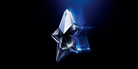 Parfumflakon in Form eines facettierten Sterns in Silber-Blau, schwebend vor dunklem, leuchtend blauem Hintergrund. Der futuristische Flakon gehört zur Duftlinie 'Angel' von Mugler.