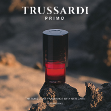 Quadratische Werbung für Trussardi Primo: Im Zentrum steht ein rot-schwarzer Parfumflakon auf Felsen in einer kargen, felsigen Landschaft. Oben der weiße Schriftzug 'TRUSSARDI PRIMO', unten der Slogan 'The masculine fragrance of a new dawn'.